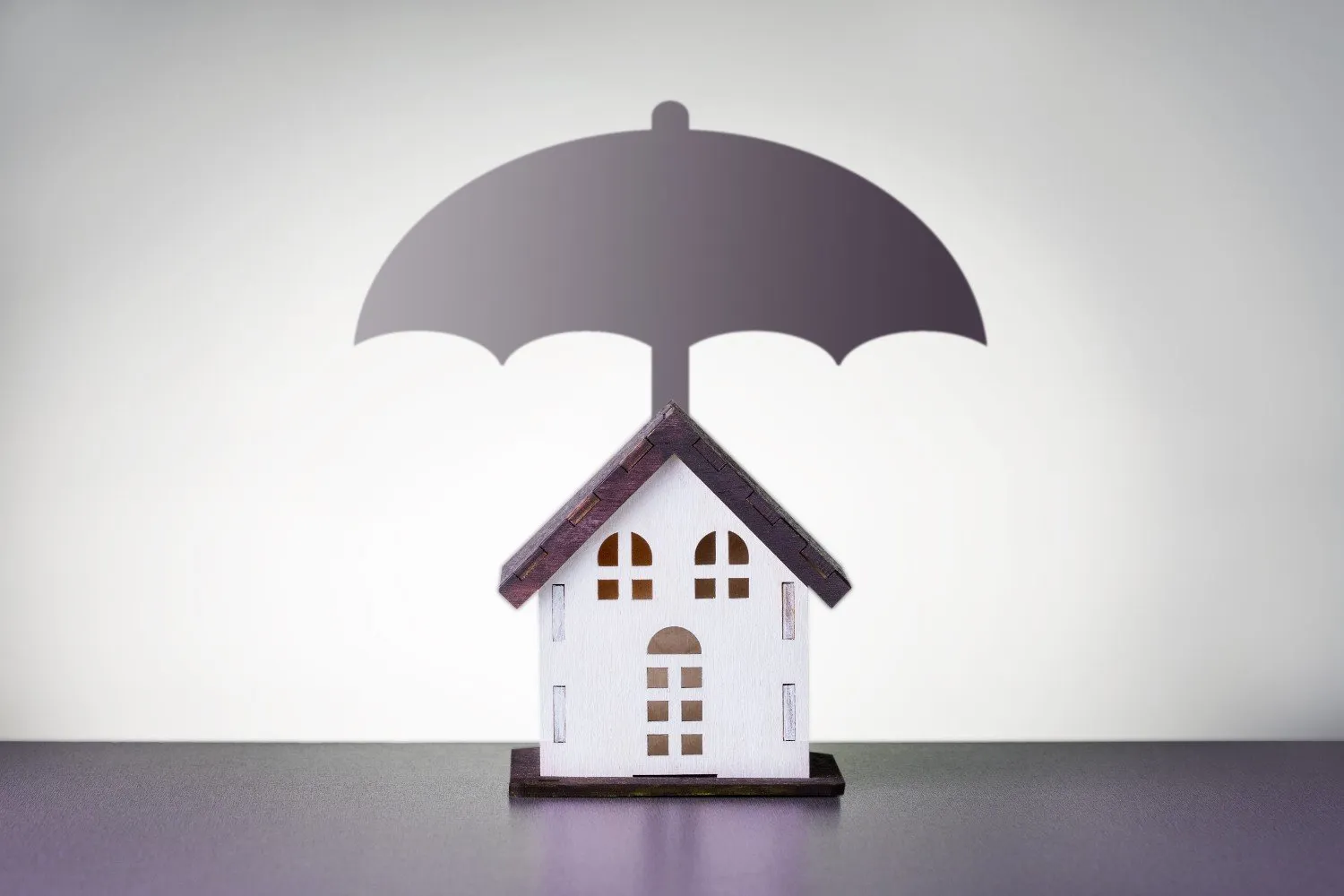 Model house sheltered under an umbrella